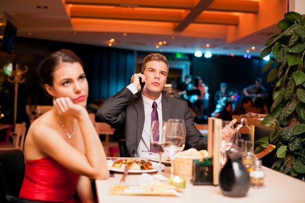 Guy busy over phone on date