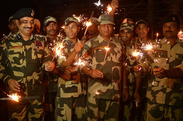 Indian Border Security Force (BSF) Deputy Inspector General (DIG), M. F. Farooqui (L) along with BSF personnel share a light moment as they play with sparklers as they celebrate Diwali along the India-Pakistan Rajatal border post, about 45Km from Amritsar, on October 23, 2014. The Hindu festival of lights, Diwali, marks the homecoming of the God Lord Ram after vanquishing the demon king Ravana and symbolises taking people from darkness to light and the victory of good over evil.AFP PHOTO/ NARINDER NANU (Photo credit should read NARINDER NANU/AFP/Getty Images)